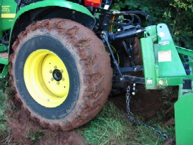 R4 tires totally plugged with wet clay, no traction to be found, tractor stuck and can foot t back up hill.